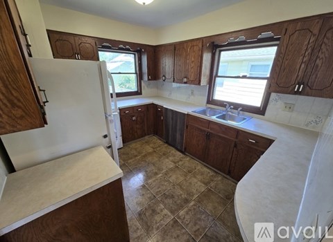 A kitchen with wooden cabinets and a tiled floor.