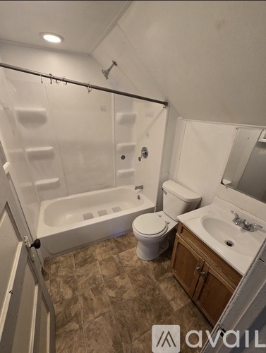 A bathroom with a tub, toilet, and sink.