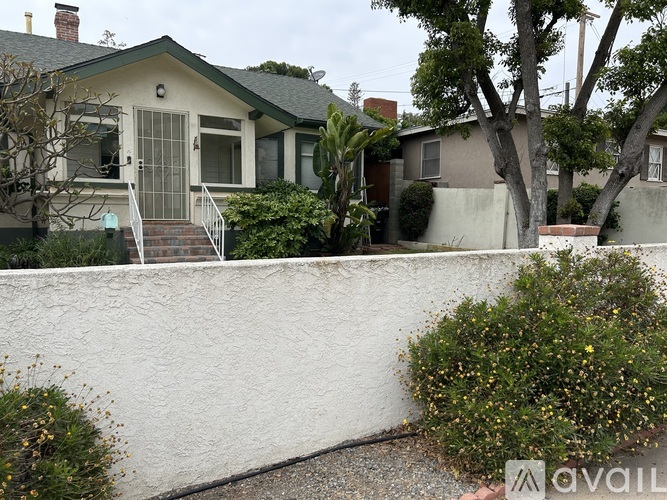 A house with a white wall and a green roof.