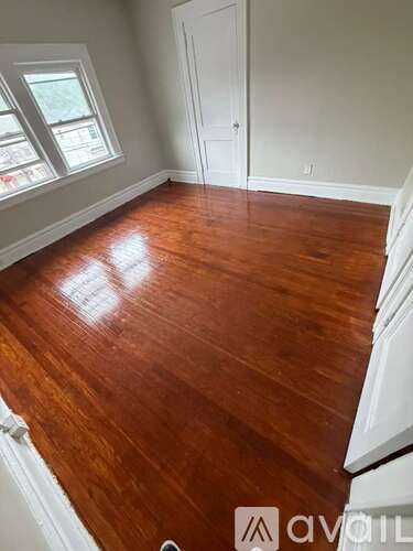 A room with wooden flooring and a white door.