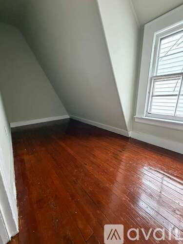 A room with wooden flooring and a window.