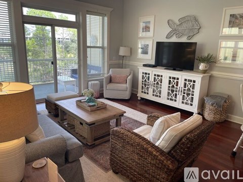 A living room with a brown wicker chair and a white cabinet with a fish decoration on top.