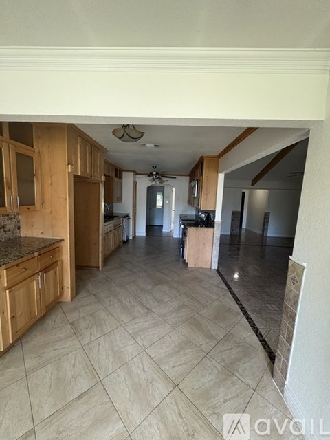 A kitchen with wooden cabinets and a tiled floor.