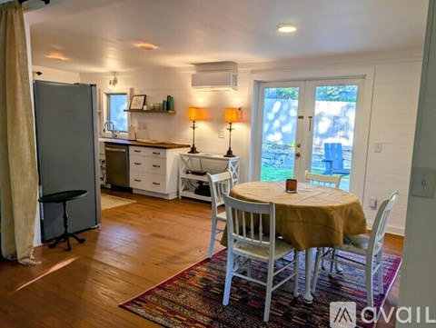 A kitchen with a table and chairs in front of a window.