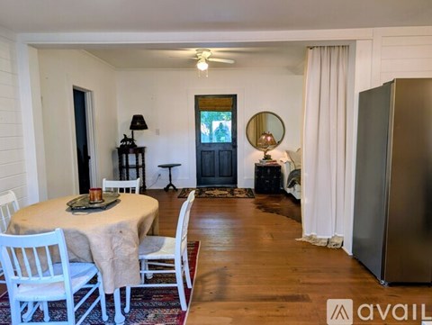 A dining room with a round table and chairs.