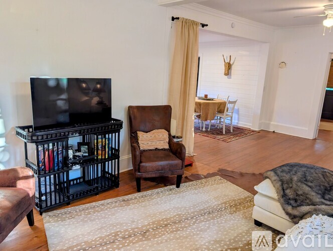 A living room with a brown leather chair and a flat screen TV.