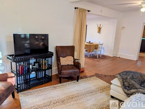 A living room with a brown leather chair and a flat screen TV.