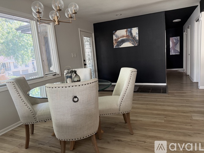 A dining room with a table and chairs.