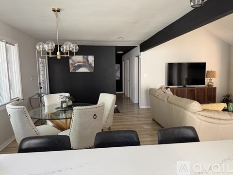 A modern living room with a glass dining table and chairs.