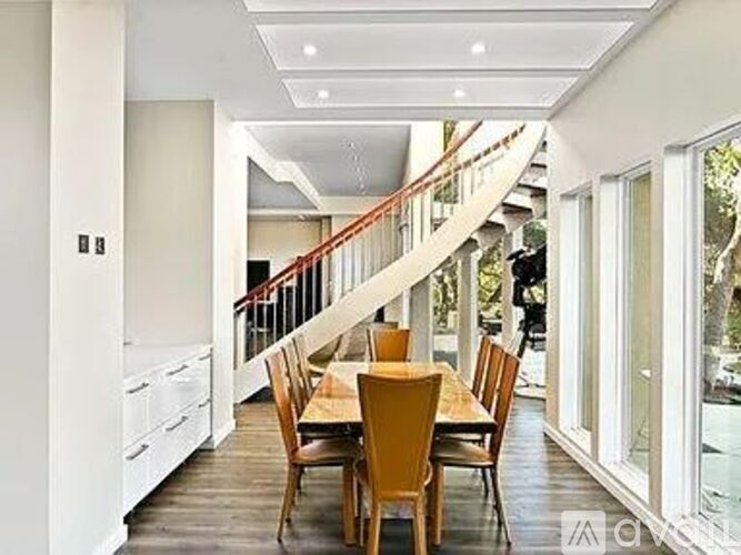 A dining room with a wooden table and chairs.