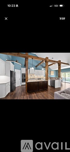 A modern kitchen with a large island and wooden beams.