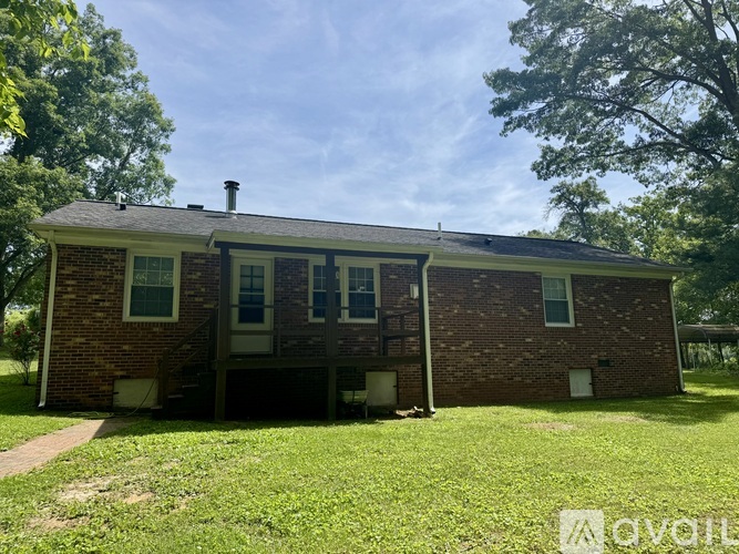 A brick house with a porch and a chimney.