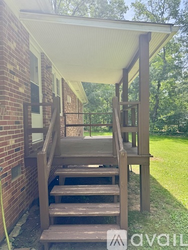 A wooden staircase with a white roof is in front of a brick building.