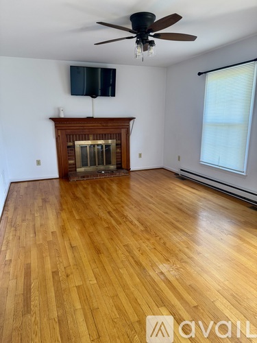 A room with a wooden floor and a fireplace.