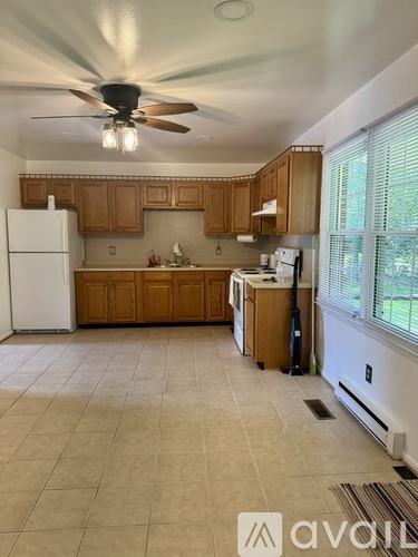 A kitchen with white appliances and wooden cabinets.
