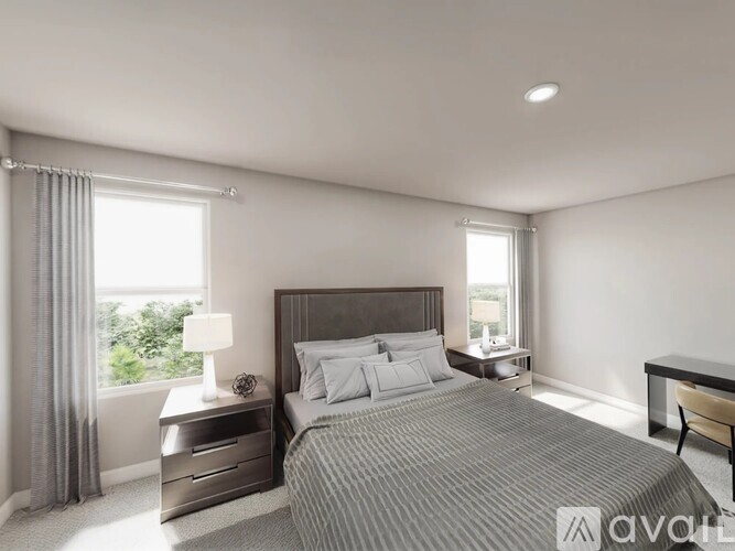 A well-lit bedroom with a large bed, nightstand, and chair.