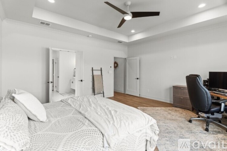 A bedroom with a large bed and a ceiling fan.