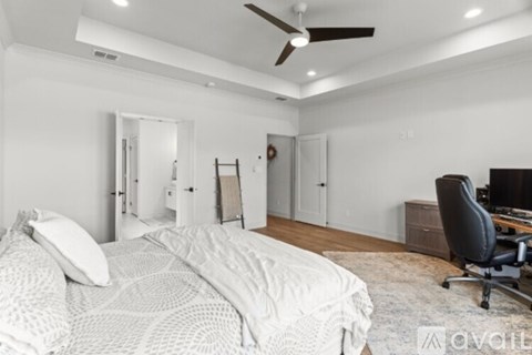 A bedroom with a large bed and a ceiling fan.