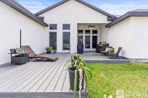A house with a white exterior and a wooden deck.