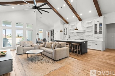 A spacious living room with a large couch and a fireplace.