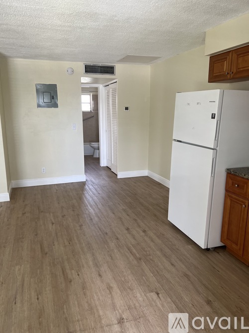 A kitchen with a white fridge and wooden cabinets.
