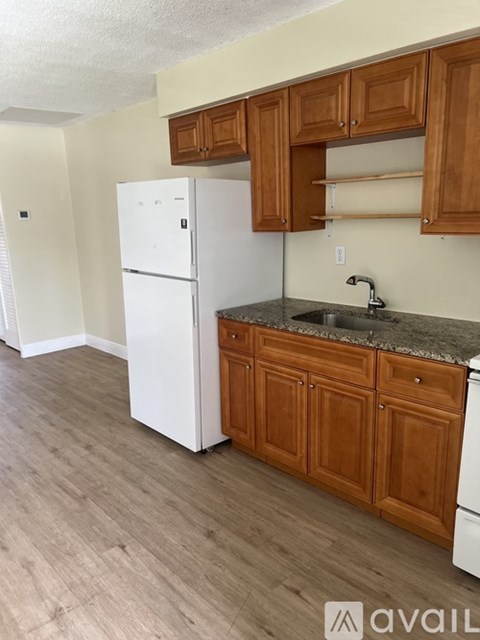 A kitchen with wooden cabinets and a white fridge.
