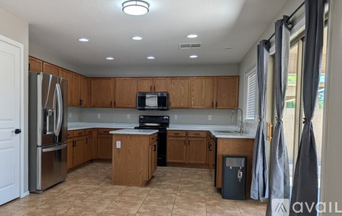 A kitchen with wooden cabinets and a stainless steel refrigerator.