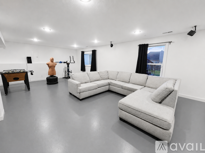 A living room with a white couch and a speaker system.