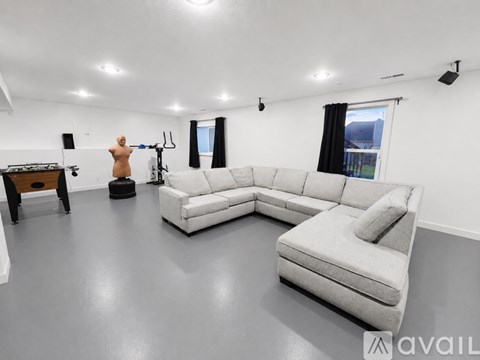 A living room with a white couch and a speaker system.