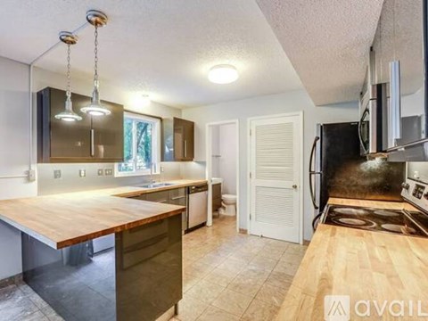 A kitchen with a wooden countertop and a microwave above it.