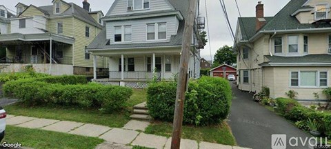 A street view of a residential area with houses and a sidewalk.