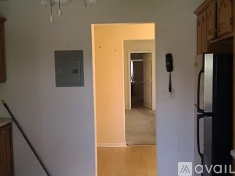 A kitchen with a refrigerator on the right and a doorway leading to another room.