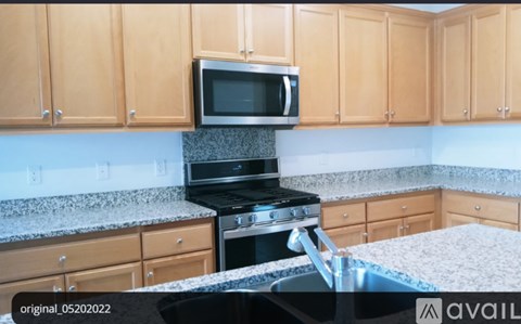 A kitchen with wooden cabinets and a black stove top oven.