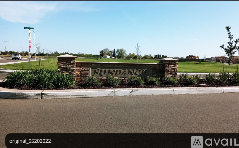 A sign that says Sunrise is in front of a grassy area.