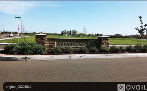 A sign that says Sunrise is in front of a grassy area.
