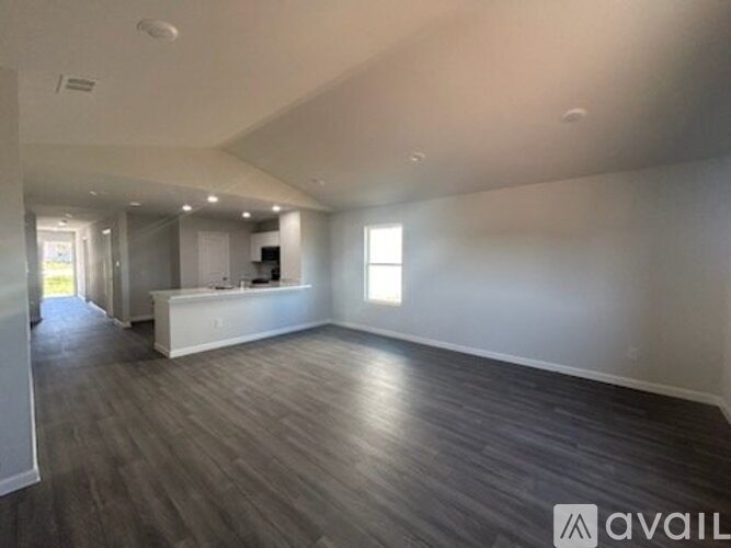 A spacious room with wooden flooring and a reception desk.