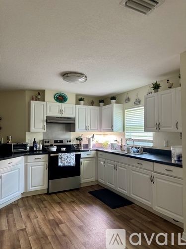A kitchen with white cabinets and a black stove top.