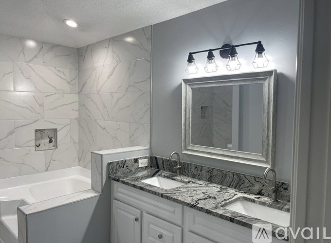 A bathroom with a marble countertop and a white bathtub.
