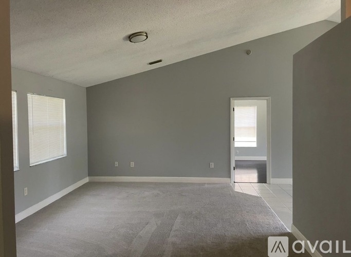 A spacious room with grey walls and a carpeted floor.