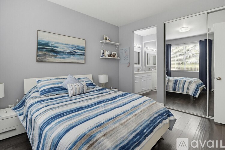 A bedroom with a large bed and a painting on the wall.