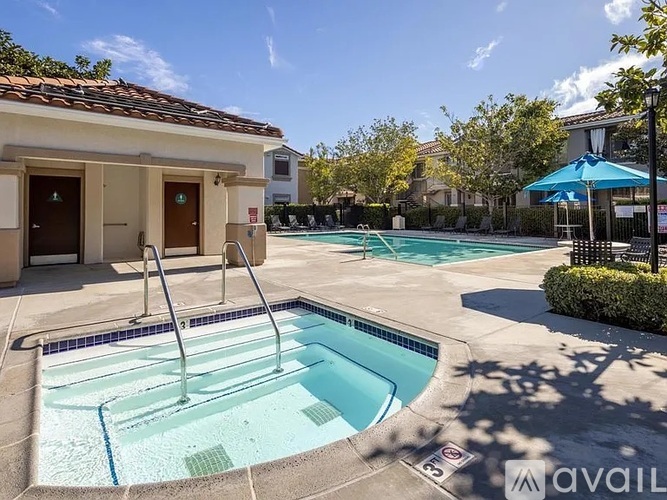 A pool with a slide and a building in the background.