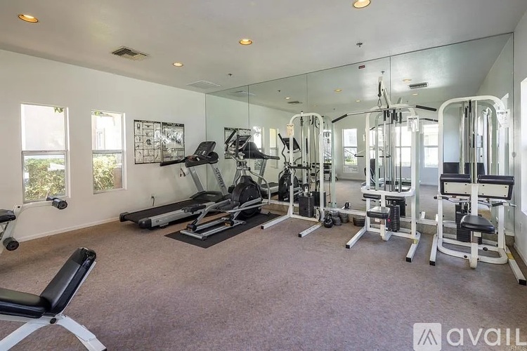 A well-equipped gym with a variety of machines and a bench.