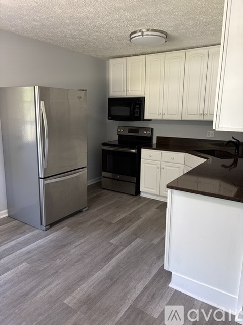 A kitchen with a refrigerator, microwave, oven, and stove.