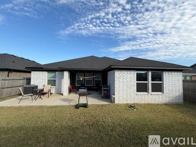 A house with a black roof and a white brick exterior is for sale.