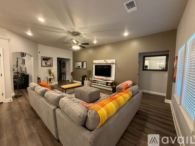 A living room with a grey couch and a television.