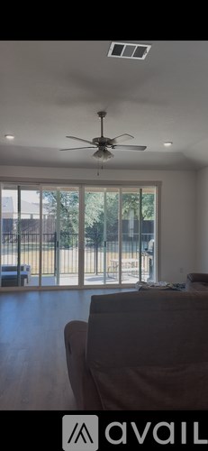 A living room with a couch and a ceiling fan.