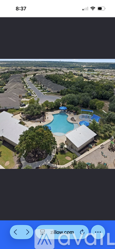 A bird's eye view of a residential area with a swimming pool and a house.