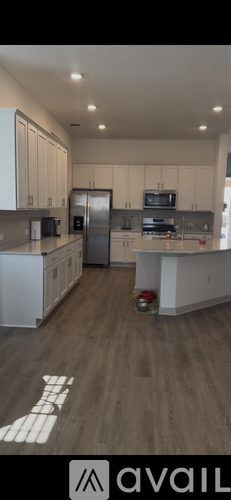 A kitchen with white cabinets and a wooden floor.