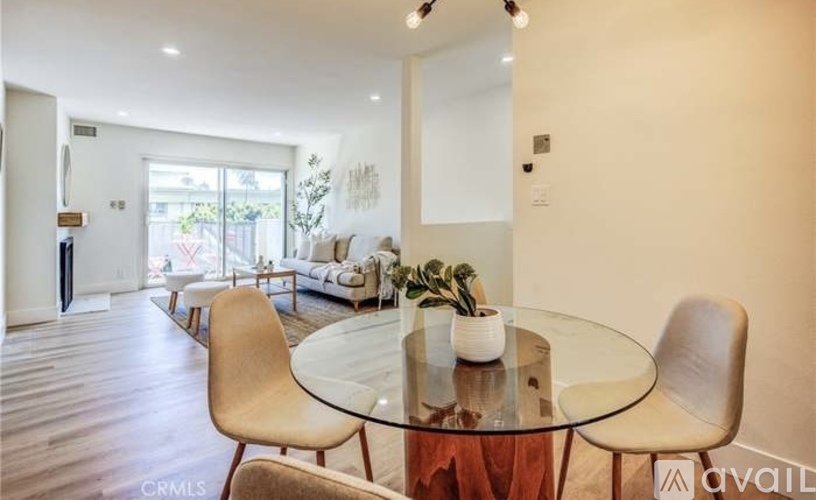 A modern dining room with a glass table and chairs.