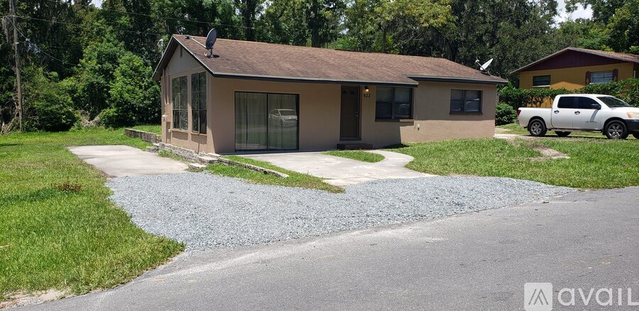 A house with a gravel driveway in front of it.